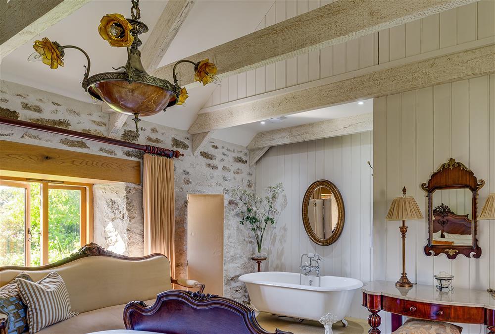 Romantic master bedroom with roll top bath and en-suite WC at Tregadjack Barn, Tregathenan