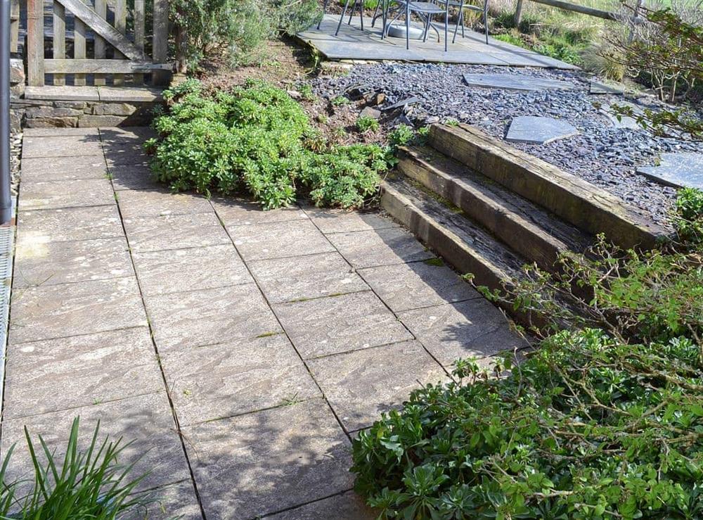 Flagged patio with railway sleeper steps at Tregella Farm Cottage in Near Padstow, Cornwall