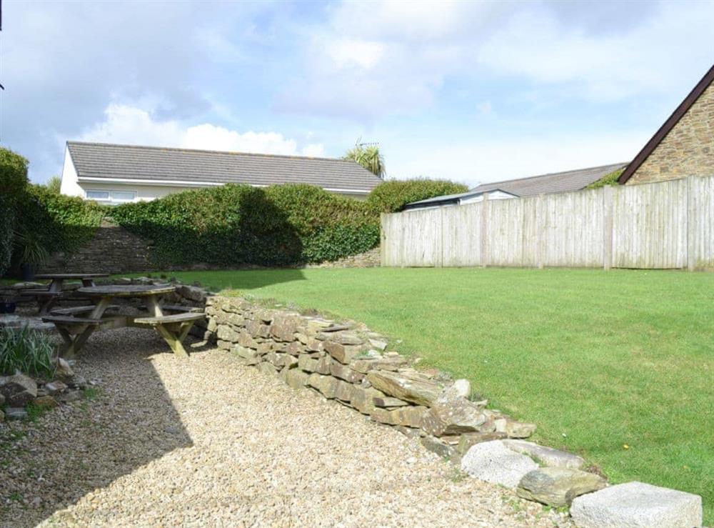 Lawned garden and gravelled patio area at Treginegar Farmhouse in St Merryn, near Padstow, Cornwall