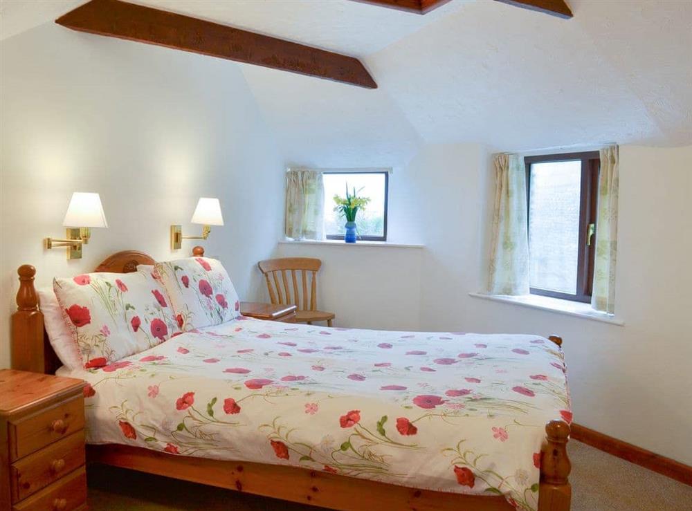 Welcoming beamed bedroom with double bed at Swallows, 