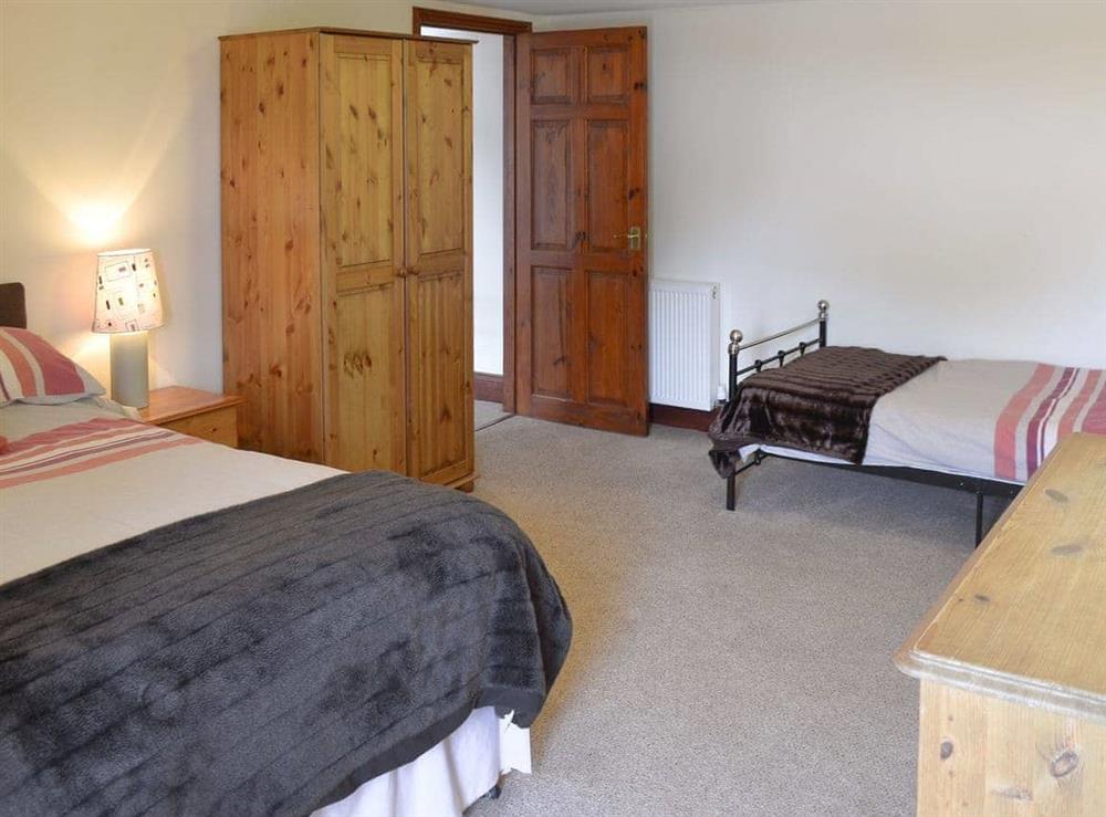 Bedroom with double bed and an additional single bed at Trescowthick Barn in St Newlyn, Cornwall