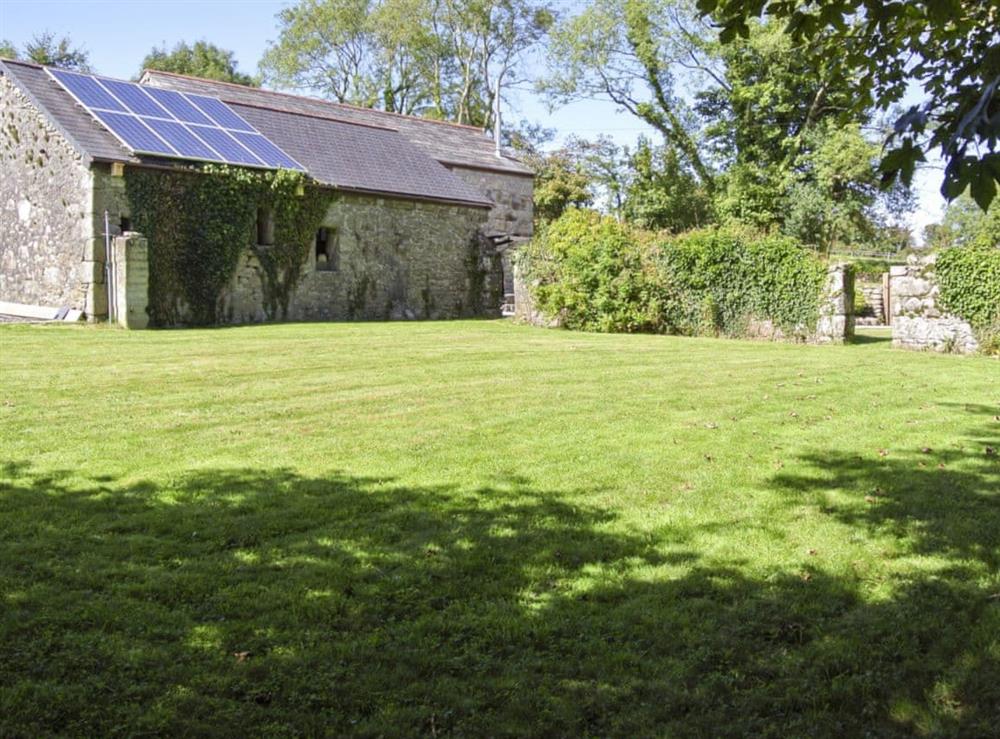 Large enclosed lawned garden with patio at Trevellyan Barn in St Austell, Cornwall