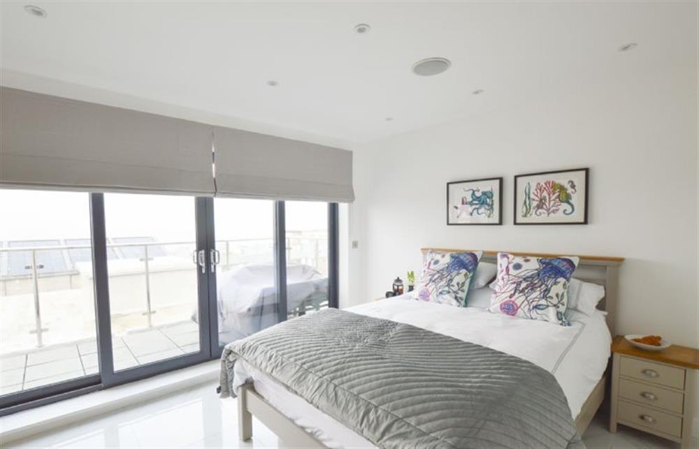 Bedroom three with king-size bed and patio doors at Trevose Penthouse, Newquay