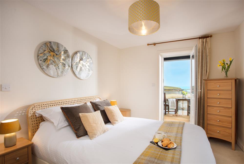 King-size bedroom with bay view balcony and en-suite shower room at Trewalder, Treyarnon Bay, St Merryn