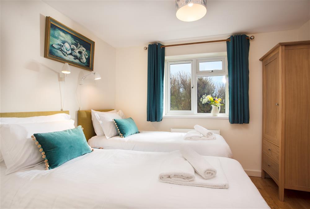 Twin bedroom with two single beds and en-suite shower room at Trewalder, Treyarnon Bay, St Merryn