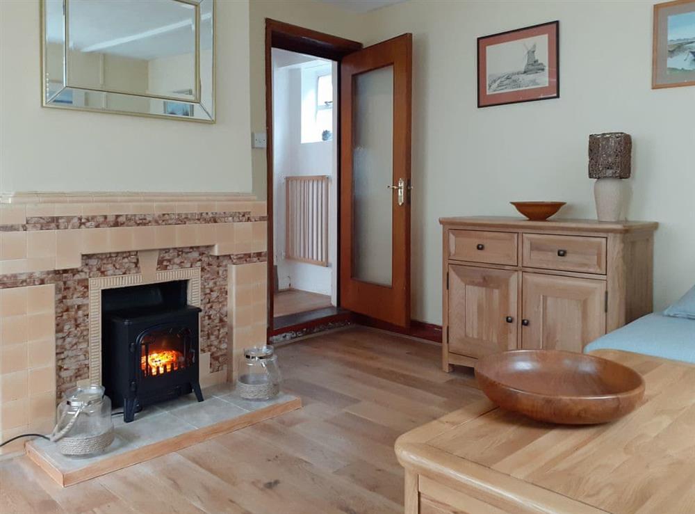 Lounge showing electric wood burning stove at Trinity Cottage in Wells-next-the-Sea, Norfolk