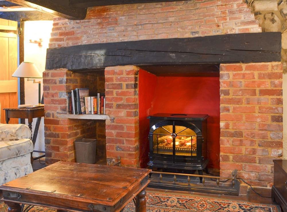 Cosy living room with feature fireplace at Tudor Cottage in Romsey, Hampshire