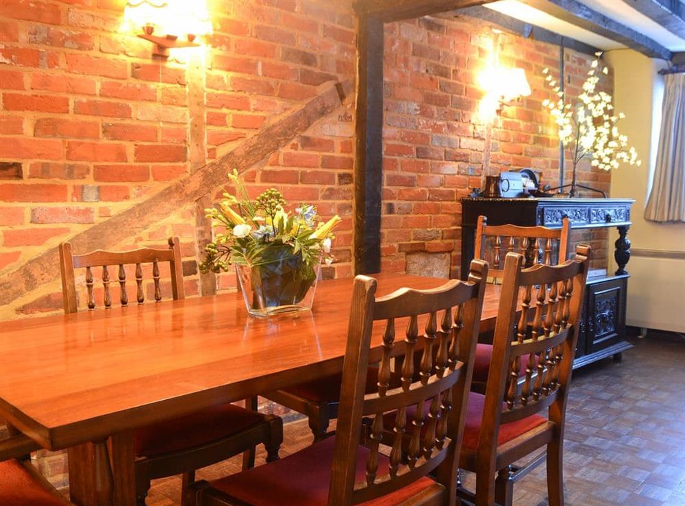 Dining room with exposed brickwork at Tudor Cottage in Romsey, Hampshire