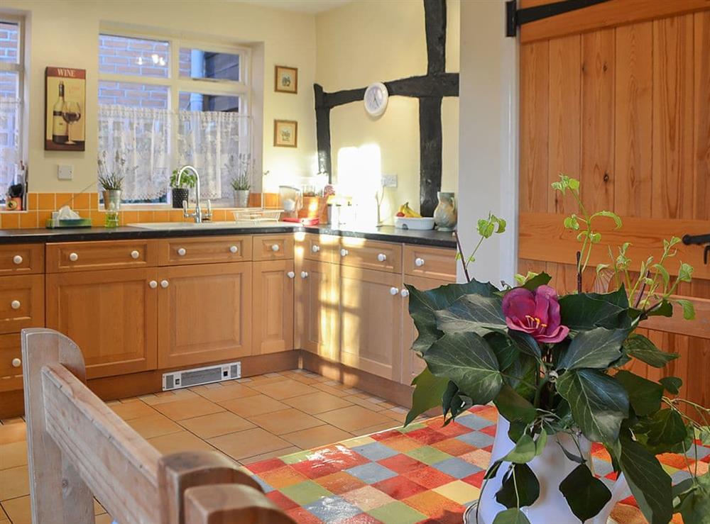 Kitchen with exposed woodwork and breakfast area at Tudor Cottage in Romsey, Hampshire