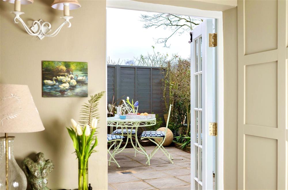 French doors lead out to the delightful garden terrace at Tudor Rose Cottage, Stourpaine
