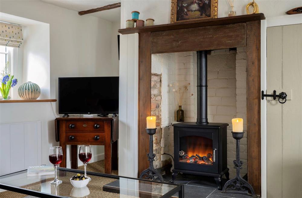 The feature electric wood burning stove and battery powered candles create a cosy glow at Tudor Rose Cottage, Stourpaine