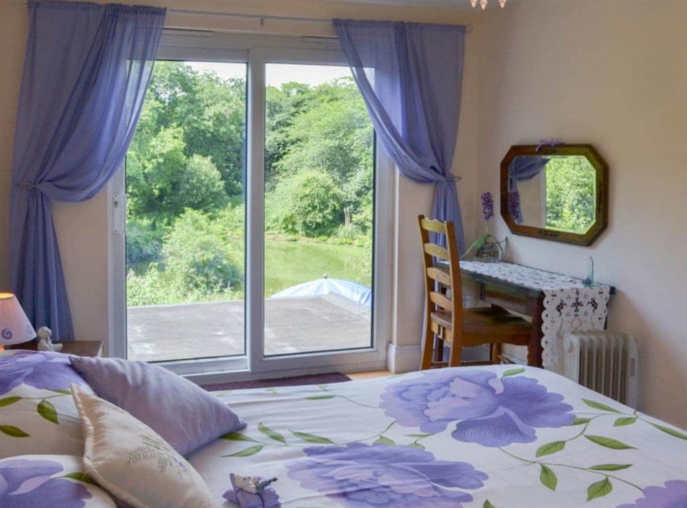 Double bedroom with sliding doors at Tulip Lodge in Tideford Cross, near Saltash, Cornwall