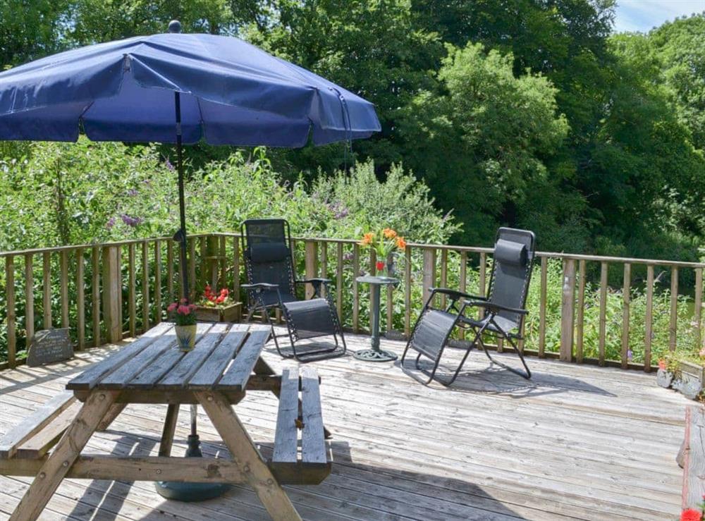 Raised decking with picnic-style outdoor eating area at Tulip Lodge in Tideford Cross, near Saltash, Cornwall