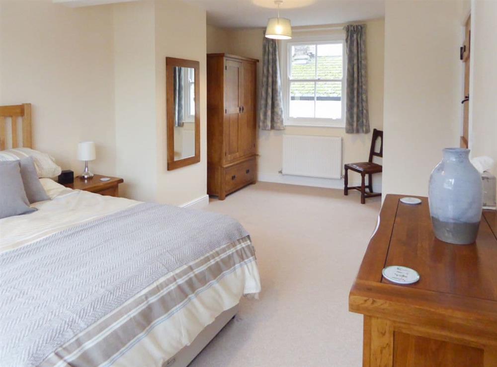 Spacious double bedroom with kingsize bed at Tuppence Cottage in Dulverton, Somerset