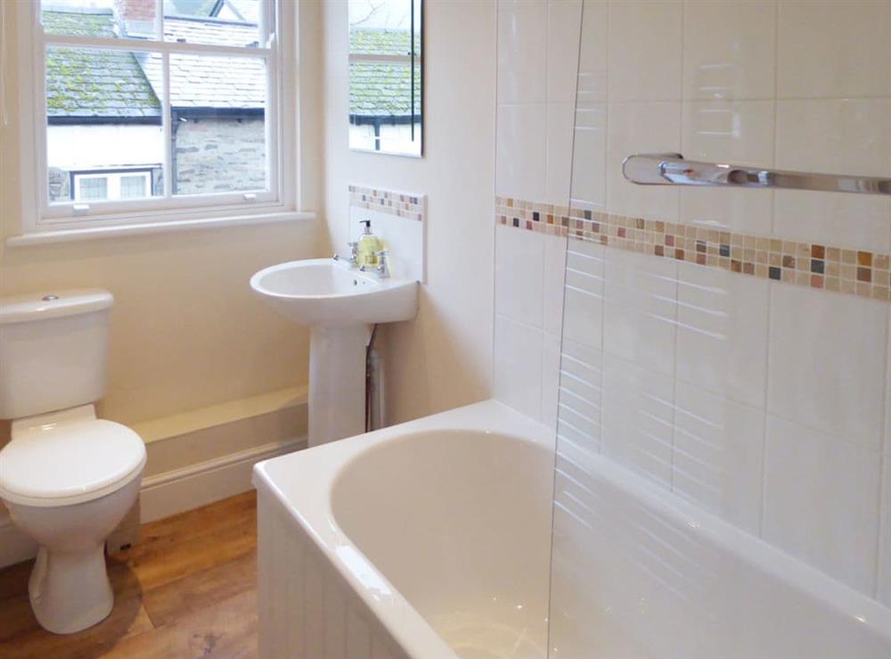 Tiled bathroom with heated towel rail at Tuppence Cottage in Dulverton, Somerset