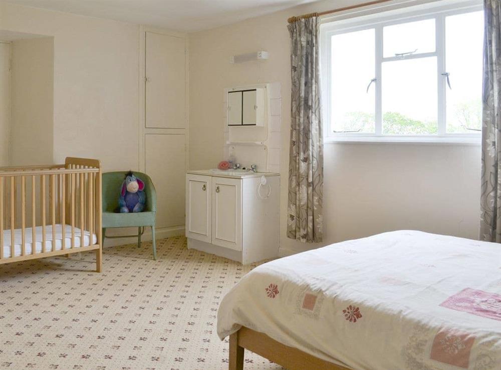 Family bedroom with double bed and cot at Tutchenor Farm in Patchacott, near Beaworthy, Devon