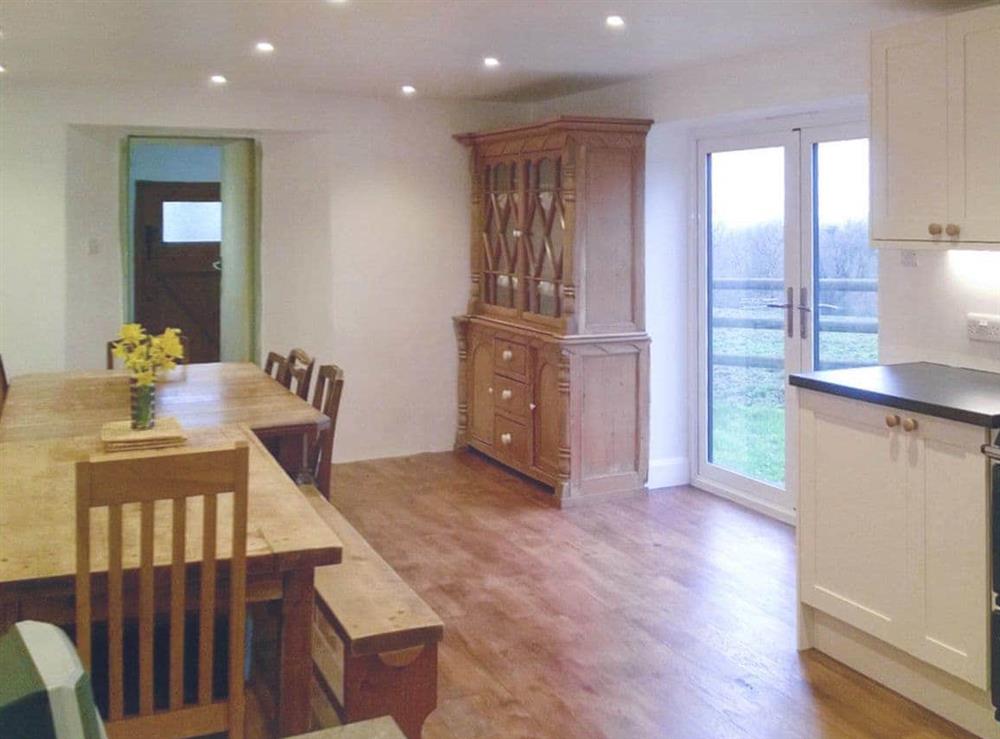 Large dining area with double doors to garden at Tutchenor Farm in Patchacott, near Beaworthy, Devon