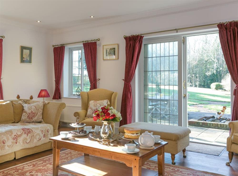 Living room with patio doors leading to garden at Twisly North Lodge in Catsfield, near Battle, Sussex, East Sussex