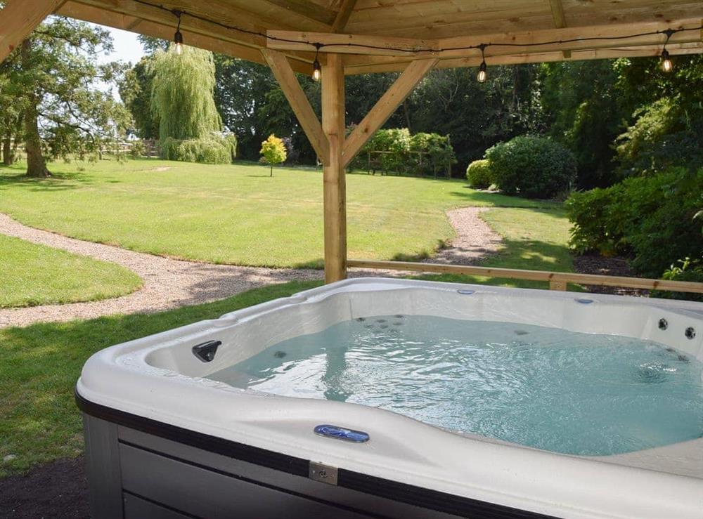 Six person hot tub set in a beautiful garden at Twisly North Lodge in Catsfield, near Battle, Sussex, East Sussex