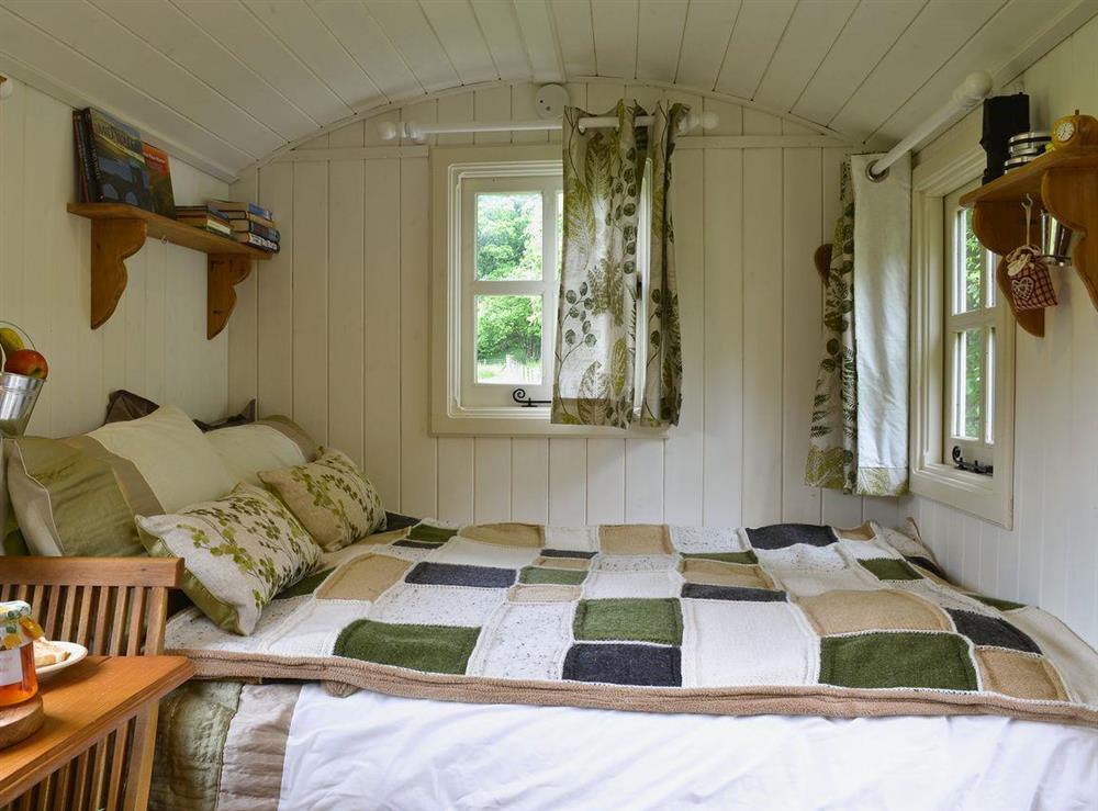 Bedroom area with double sofa bed at Ty Bach Shepherds Hut in Franksbridge, near Builth Wells, West Yorkshire