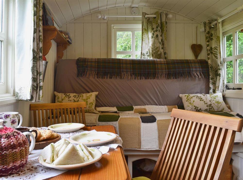 Dining area and double sofa bed at Ty Bach Shepherds Hut in Franksbridge, near Builth Wells, West Yorkshire