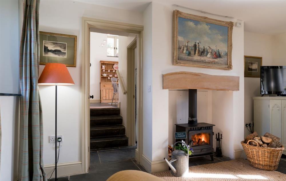 Steps lead down from the kitchen to the sitting room with woodburning stove at Ty Cerrig, Bodnant Estate