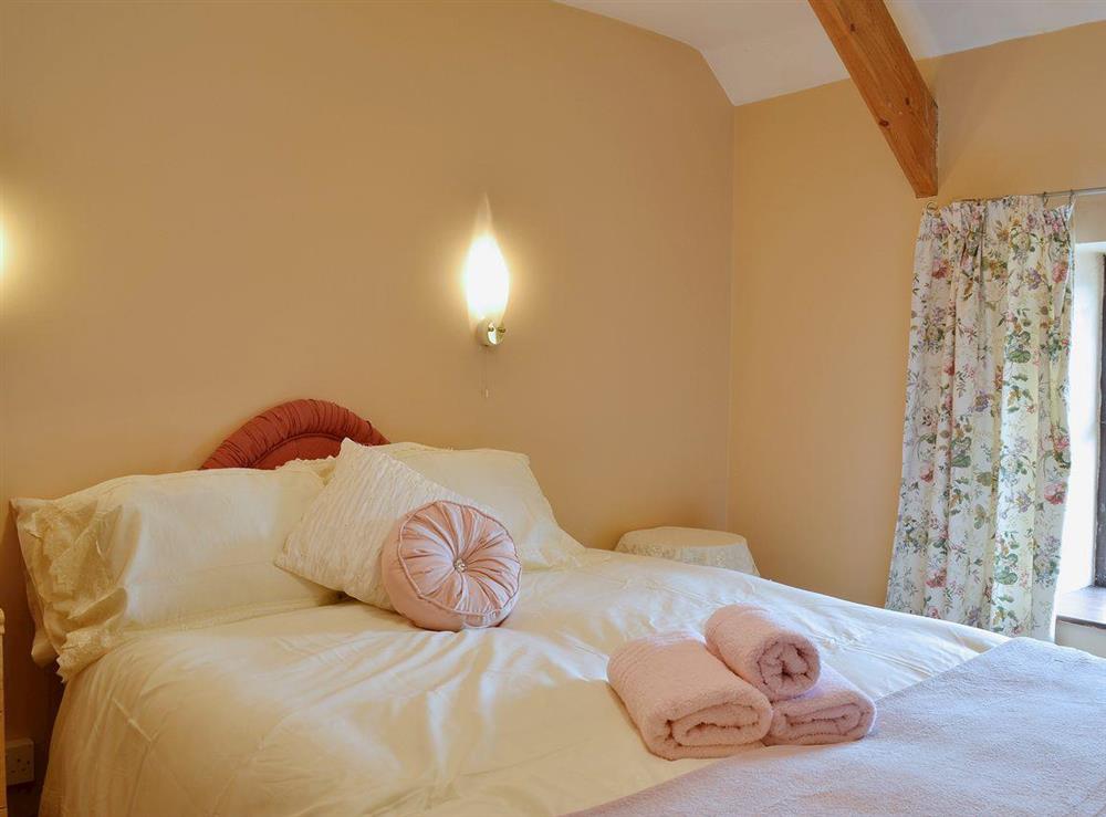 Romantic double bedroom with exposed woodwork at Ty Coch Cottage in Near Aberaeron, Dyfed