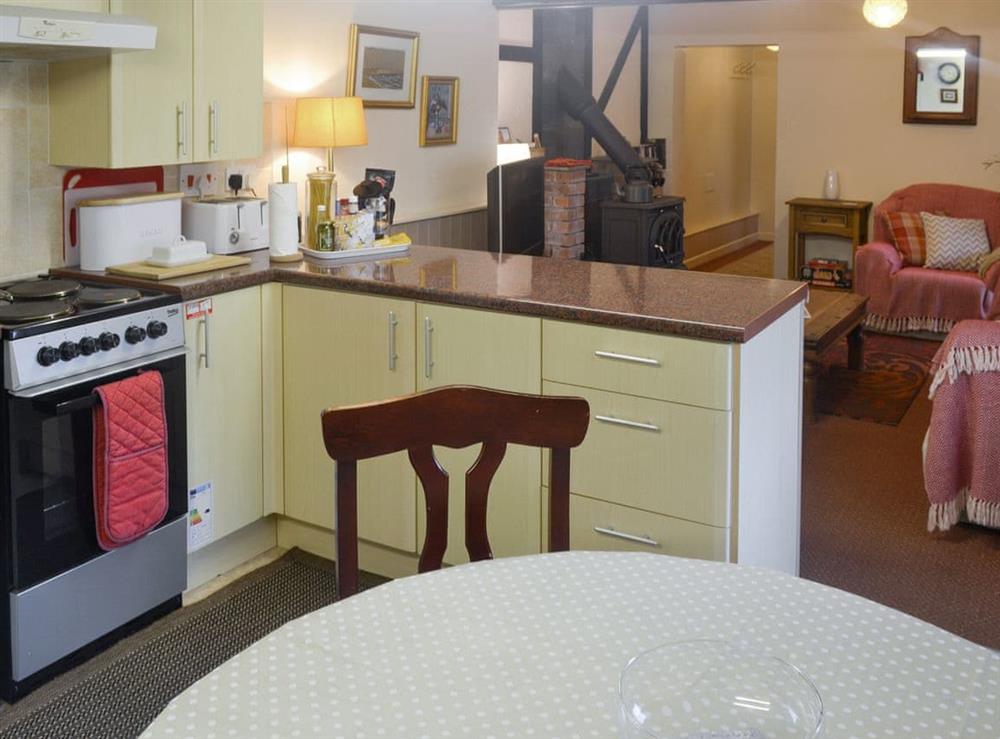 Fully equipped kitchen with dining area within the open-plan design at The Den, 
