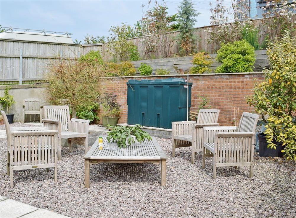 Enclosed patio with garden furniture and BBQ at Ty Cornel in Aberporth, near Cardigan, Dyfed