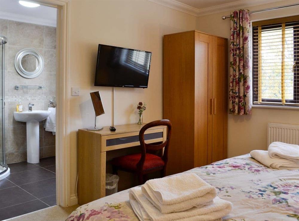 Bedroom boasting an en-suite shower room at Ty Glyndwr in Lower Cwm-twrch, near Llandovery, Powys