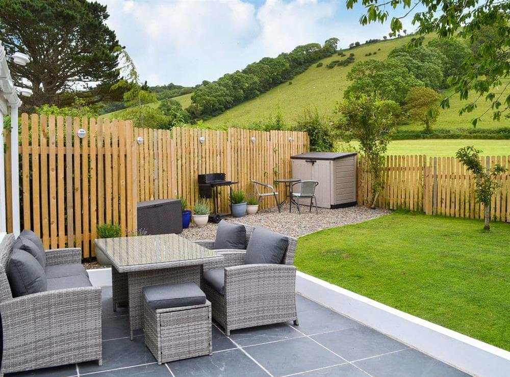 Enclosed lawned garden with patio, garden furniture and BBQ at Ty Gwyn in Cei Bach, near New Quay, Cardigan, Dyfed