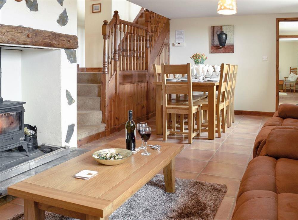 Spacious lounge with wood burning fire and dining area at Ty Hir in Arthog, Fairbourne, Gwynedd