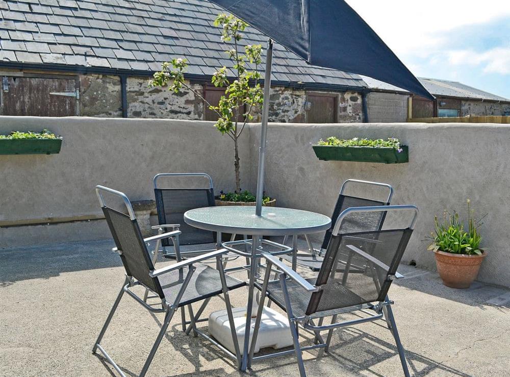 Courtyard with outdoor dining furniture at Ty Main Cottage in Newborough, near Llangefni, Anglesey, Gwynedd