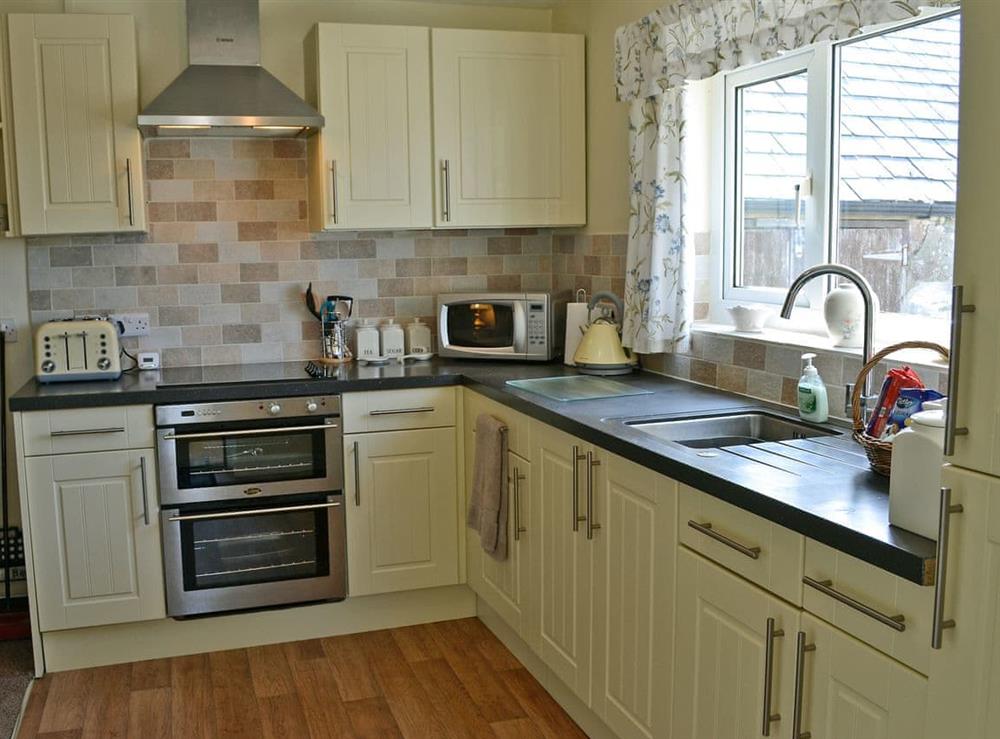 Fully equipped kitchen with electric oven, electric hob, microwave, fridge/freezer and washing machine at Ty Main Cottage in Newborough, near Llangefni, Anglesey, Gwynedd
