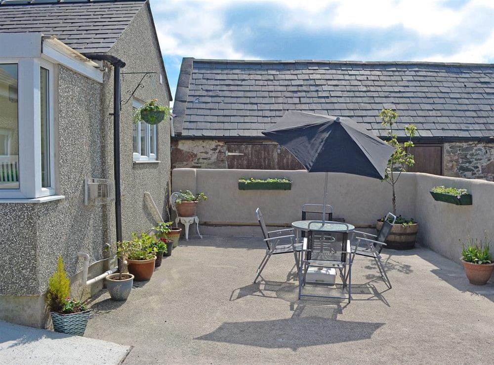 Pretty courtyard with garden furniture and BBQ at Ty Main Cottage in Newborough, near Llangefni, Anglesey, Gwynedd