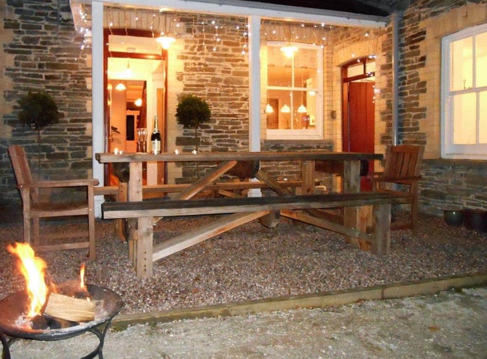 Outdoor seating area at night warmed by the ‘fire-pit’ at Tyllwyd Farmhouse in Capel Bangor, near Aberystwyth, Dyfed