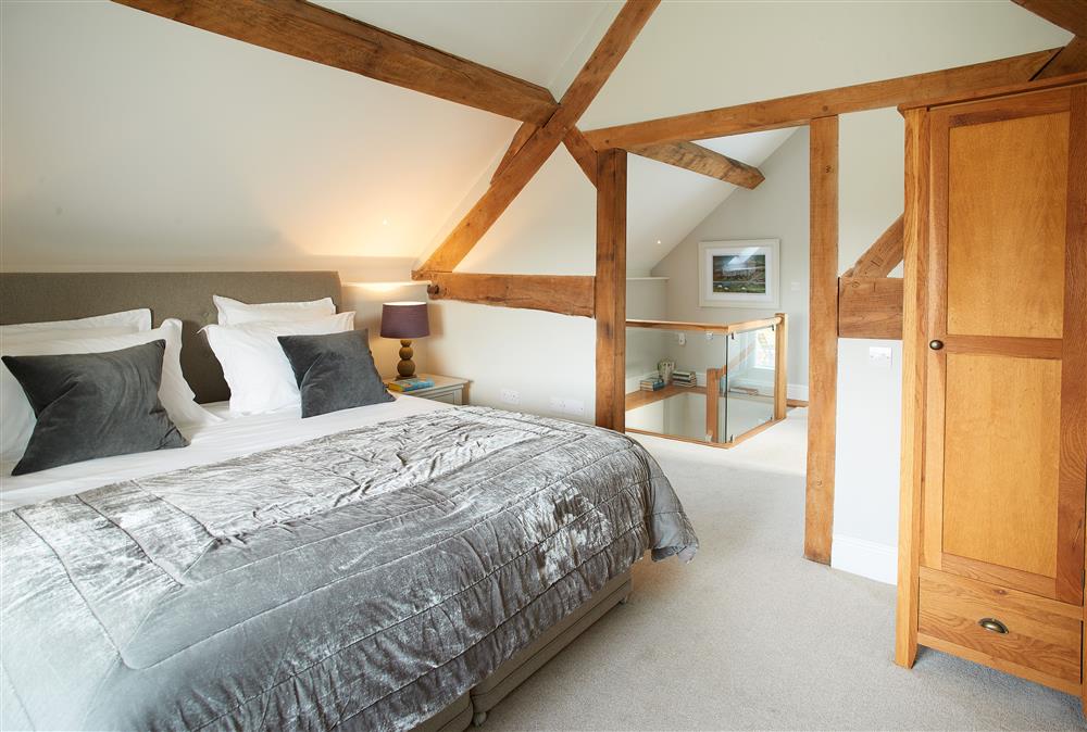 Unconformity Barn, Shropshire: Bedroom with a 6ft super-king size bed with exposed beams at Unconformity Barn, Hope Bowdler, near Church Stretton