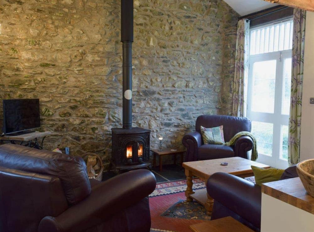 Cosy living area with wood burner at Ravens Roost, 