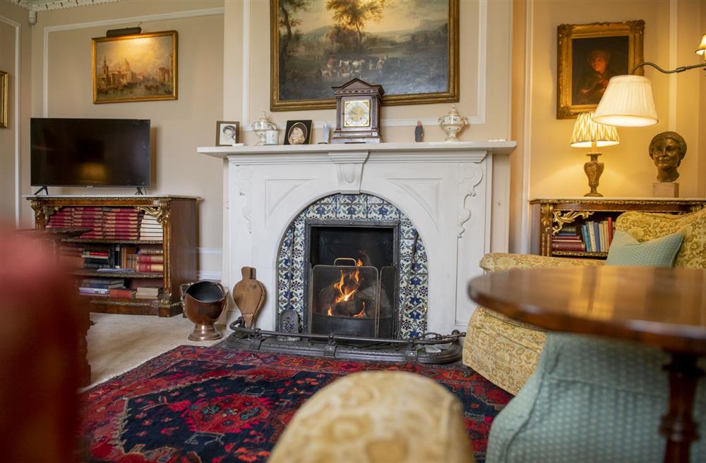 Drawing room with a cosy open fire at Upper Helmsley Hall, York