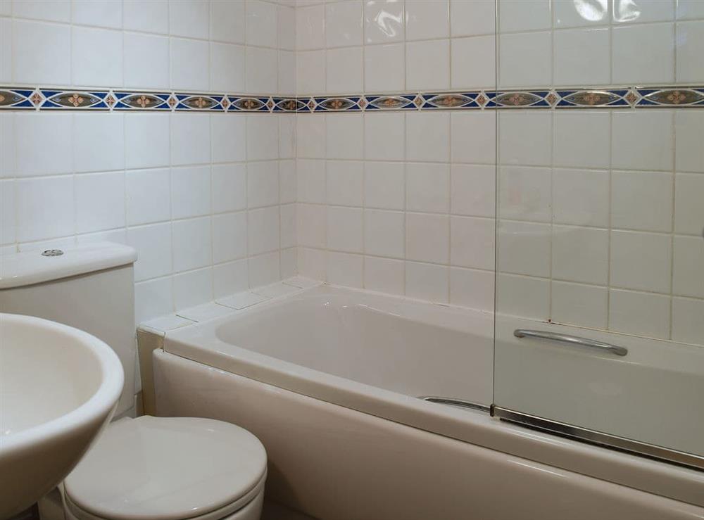 Attractive tiled bathroom with shower over bedroom at Valeview Cottage in Great Malvern, Worcestershire, England