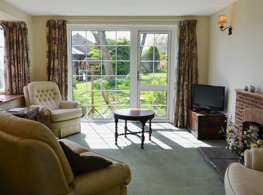 Relaxing living room with patio doors leading to the garden at Valley View in Dalwood, near Axminster, Devon