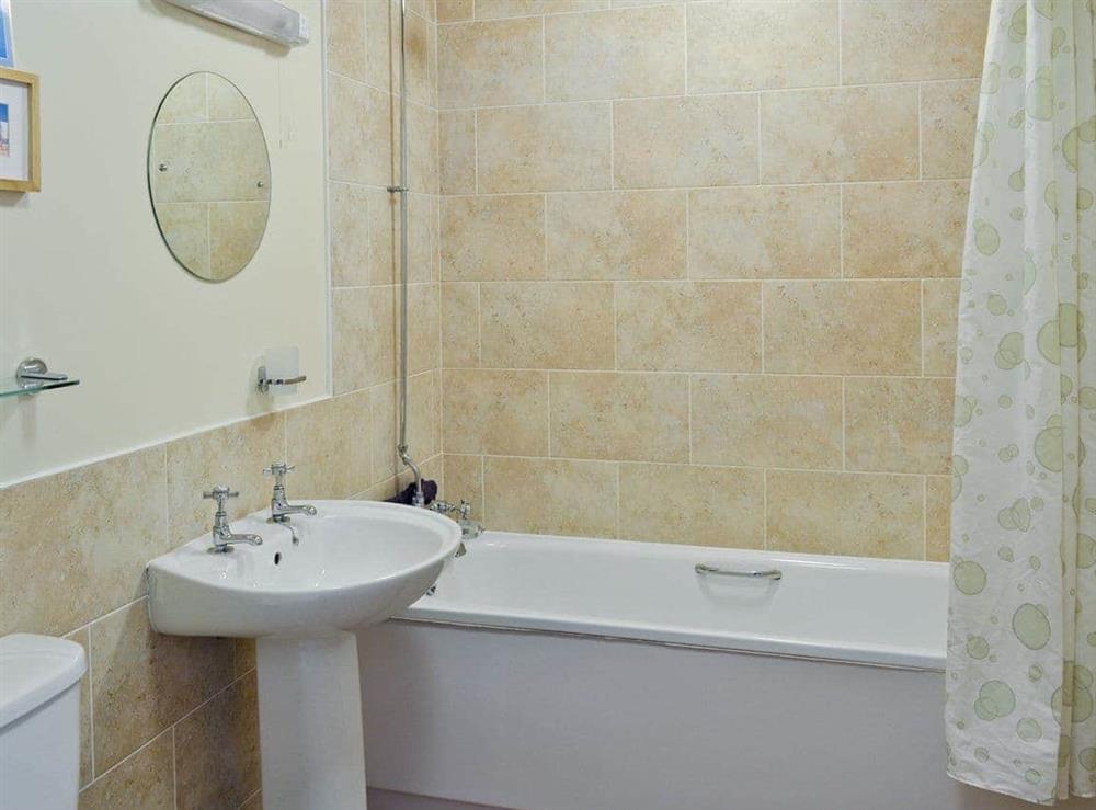 Family bathroom with shower over bath at Vaughan Cottage in Muston, Filey, North Yorkshire