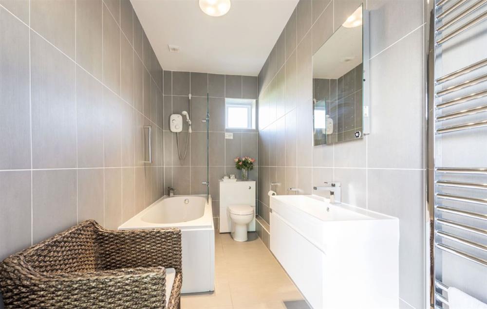 En-suite bathroom with bath and shower over at Veronica Cottage, Anvil Point Lighthouse