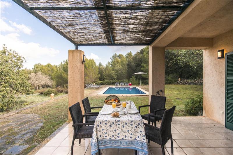 Garden and shaded outdoor dining area at Villa Hortensia, Arta, Spain
