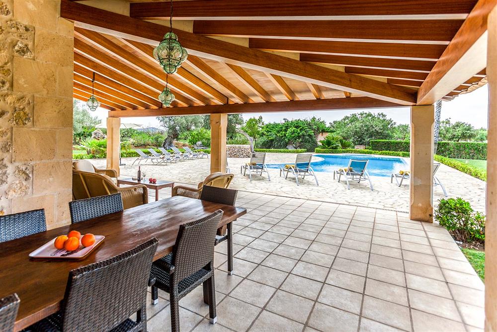 Covered terrace, alfresco dining, sunloungers at Villa Les Oliveres, Puerto Pollensa, Mallorca