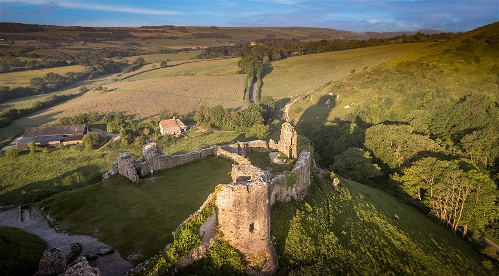 An aerial view of the ruins of Corfe Castle with Vineyard Farm Cottage in the background, Dorset at Vineyard Farm Cottage in Wareham, Dorset