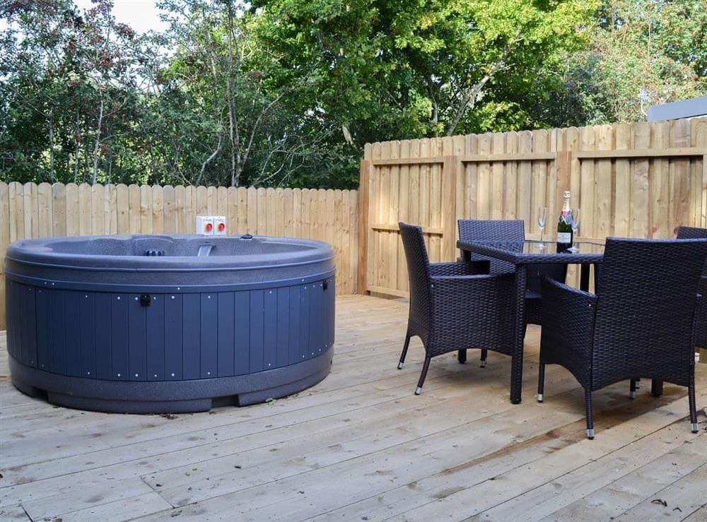 Relax and enjoy the private hot tub at Curlew Lodge, 