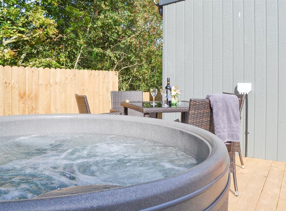 Decked area with hot tub and outdoor eating area at Lapwing, 