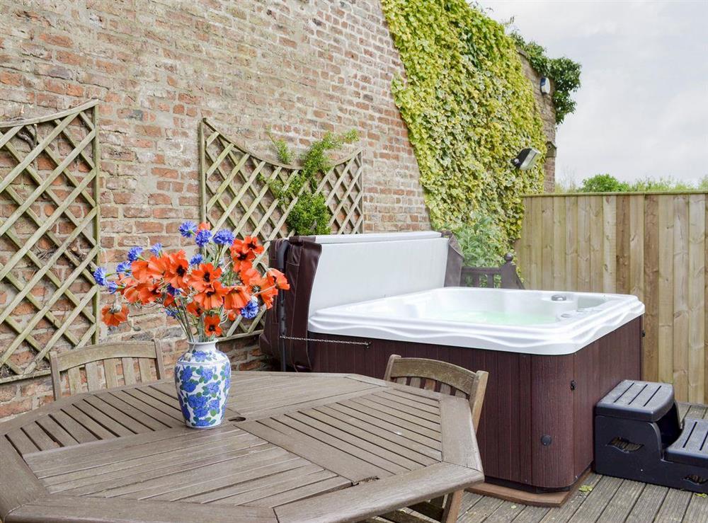 Decked patio with outdoor furniture and hot tub at Walled Garden Lodge in Camerton, near Hull, North Humberside