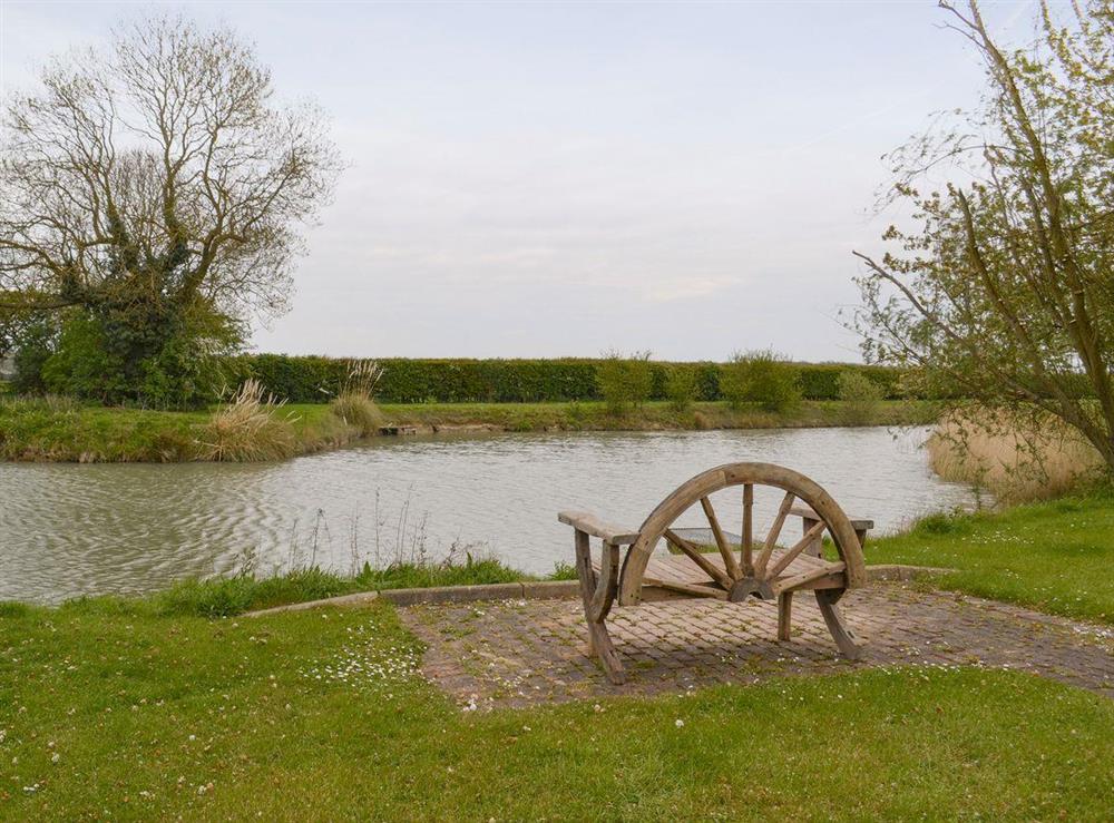 Seating area beside the well-stocked fishing lake at Carp Cottage, 